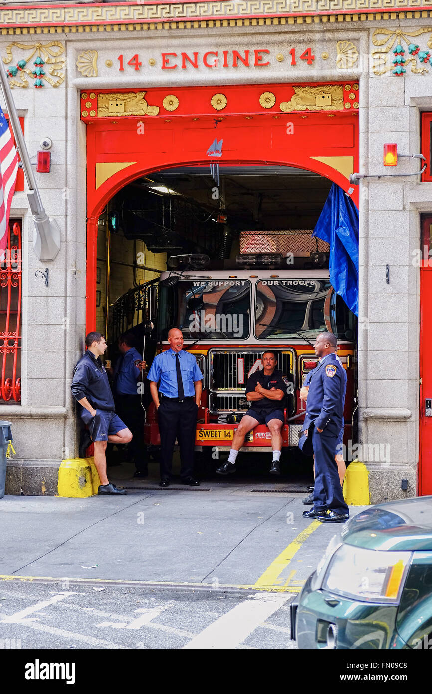 NEW YORK CITY - 8 octobre 2014 : les pompiers de New York en faisant une pause assis sur le chariot à moteur 14 dans East 18th Street Banque D'Images