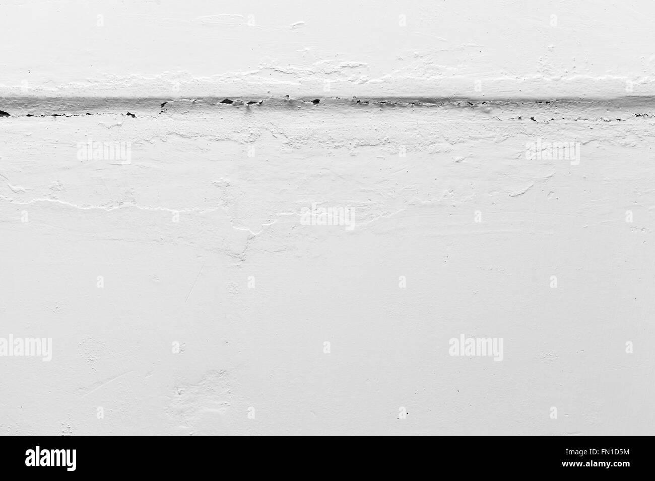 Fissure horizontale dans le mur peint en blanc, texture photo gros plan Banque D'Images