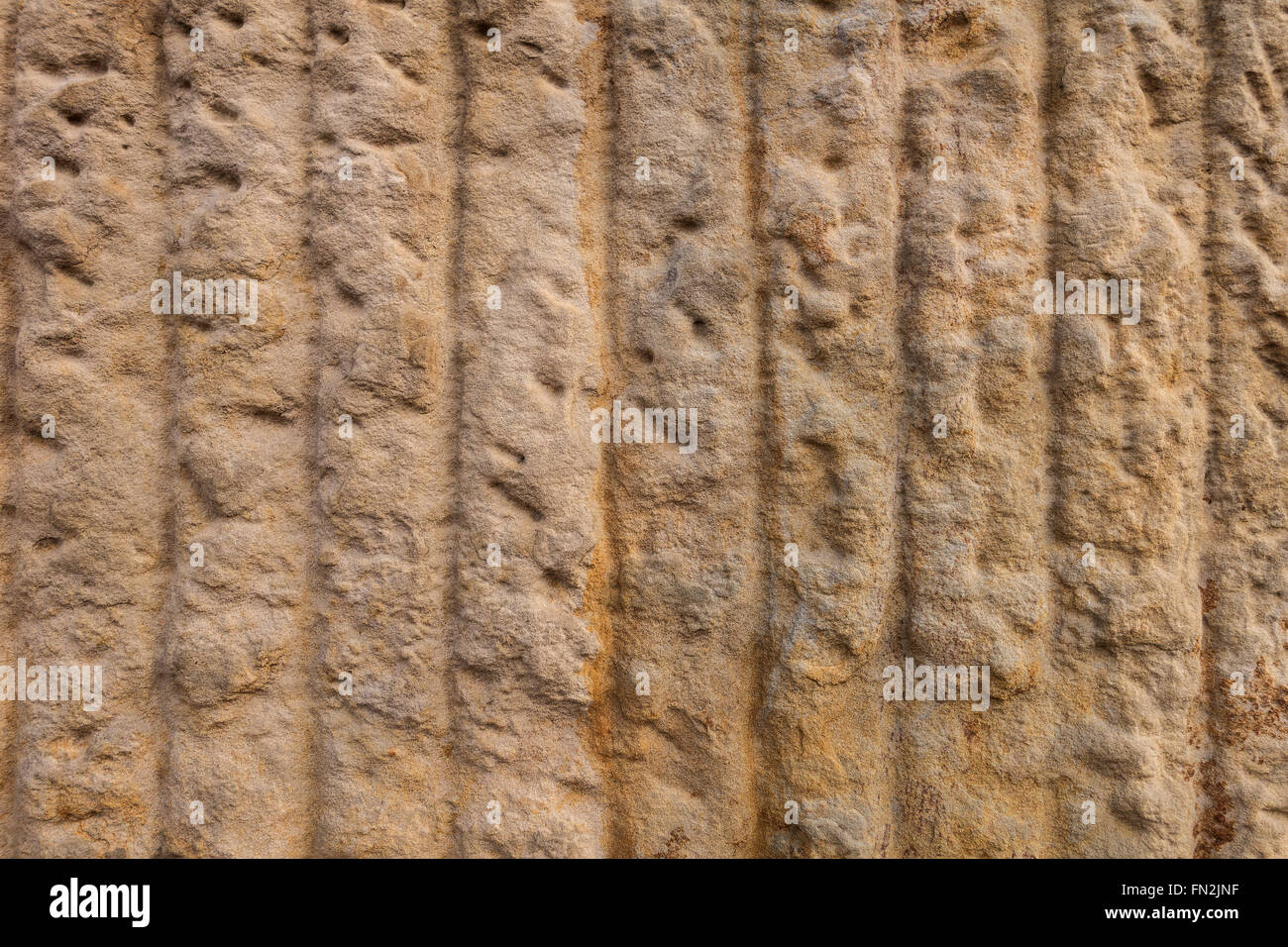 Abstract brown texture de grès avec des lignes verticales taillées dans une grosse surface. Prises en gros plan. Banque D'Images