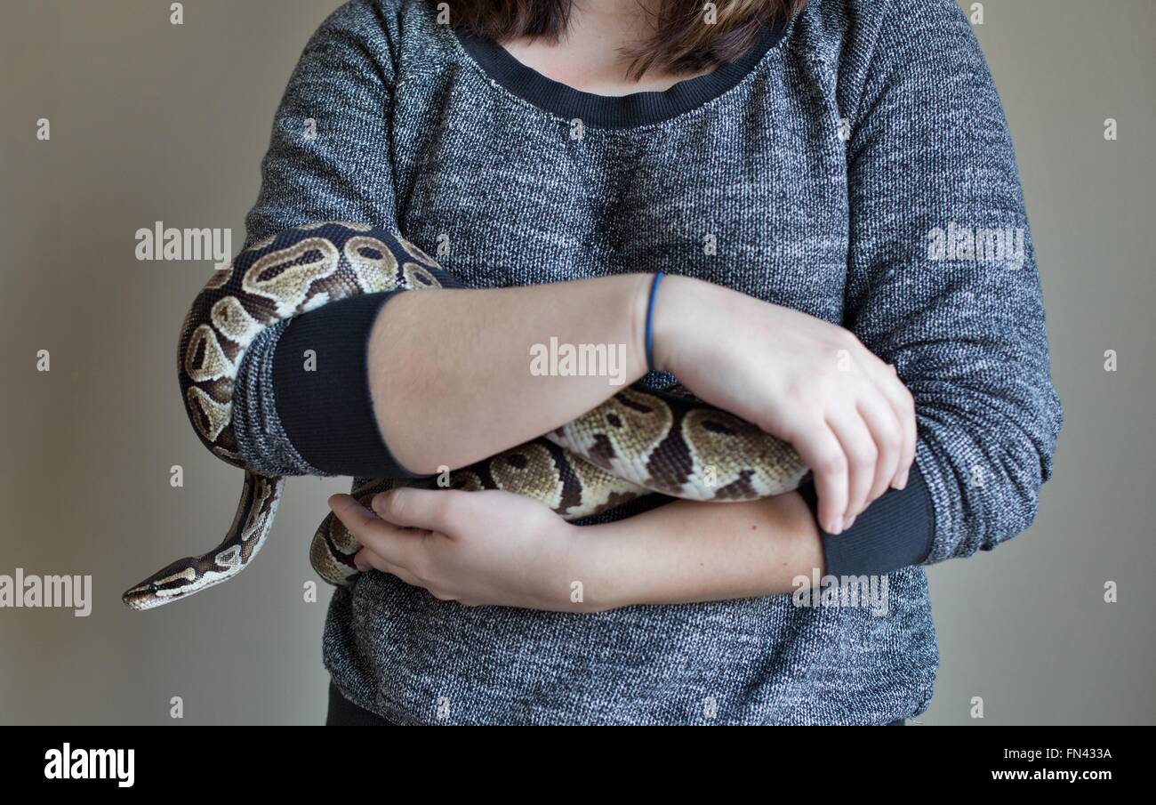 Un gros plan d'une femme tenant une boule serpent Python. Banque D'Images