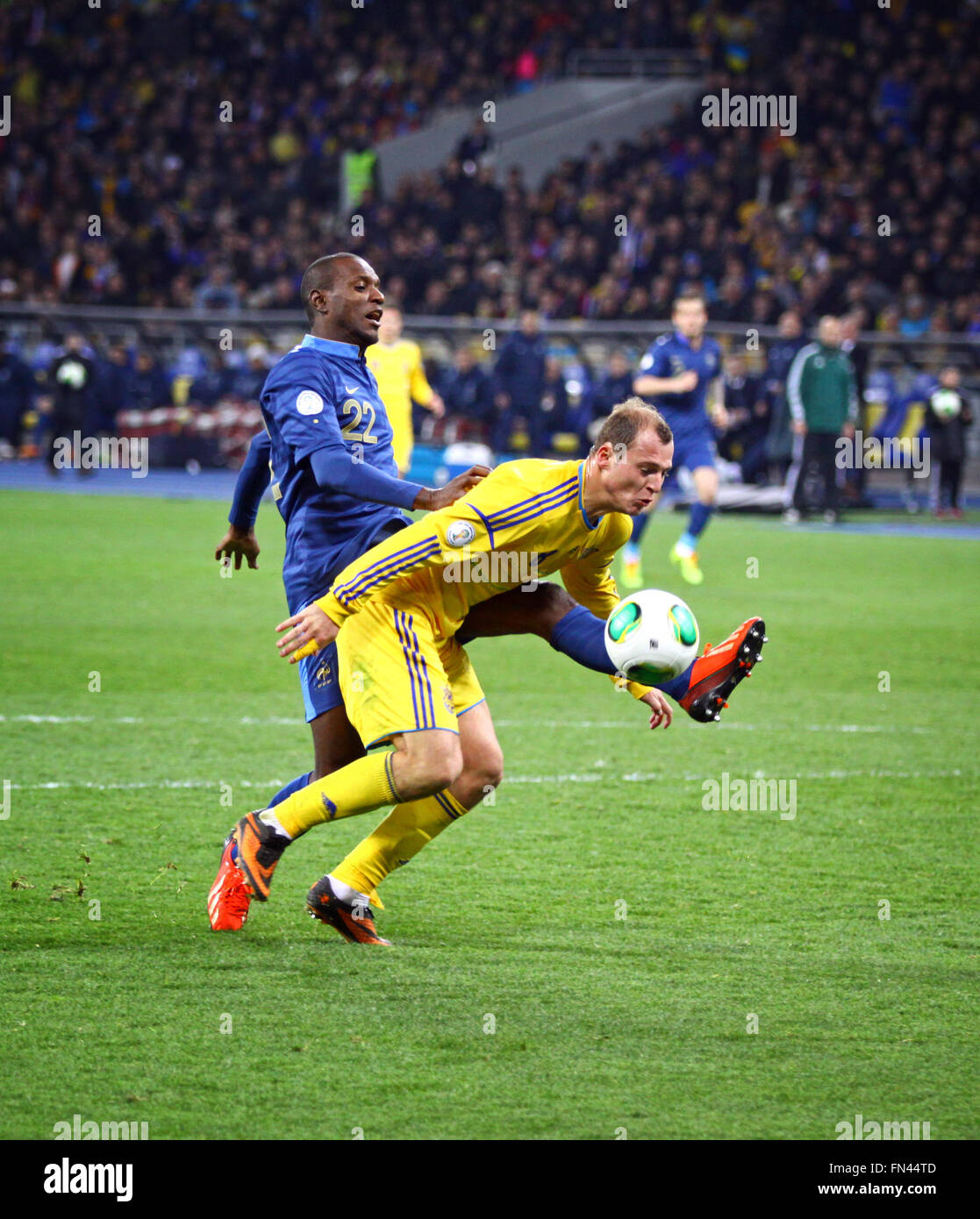 Kiev, UKRAINE - le 15 novembre 2013 : Roman Zozulya de l'Ukraine (en jaune) se bat pour une balle avec Eric Abidal de France au cours de thei Banque D'Images