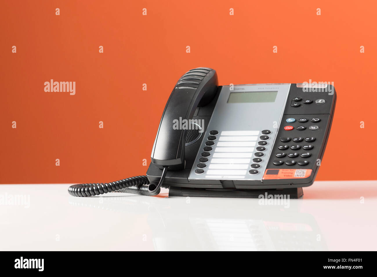 Téléphone de bureau sur un fond orange. Banque D'Images