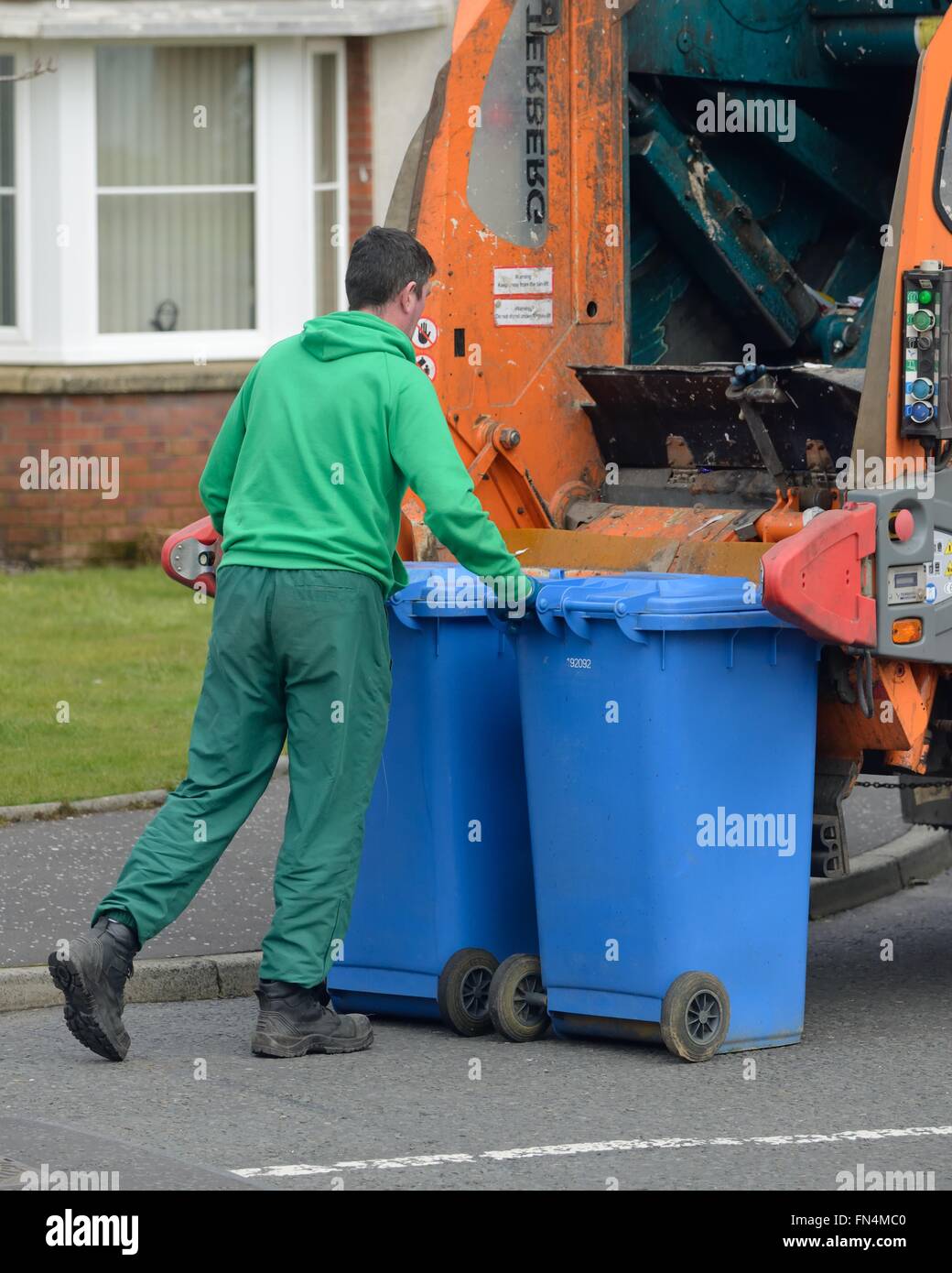 Travailleur du Conseil de vider les bacs de recyclage des déchets wheelie en refuser camion à Glasgow, Ecosse Banque D'Images