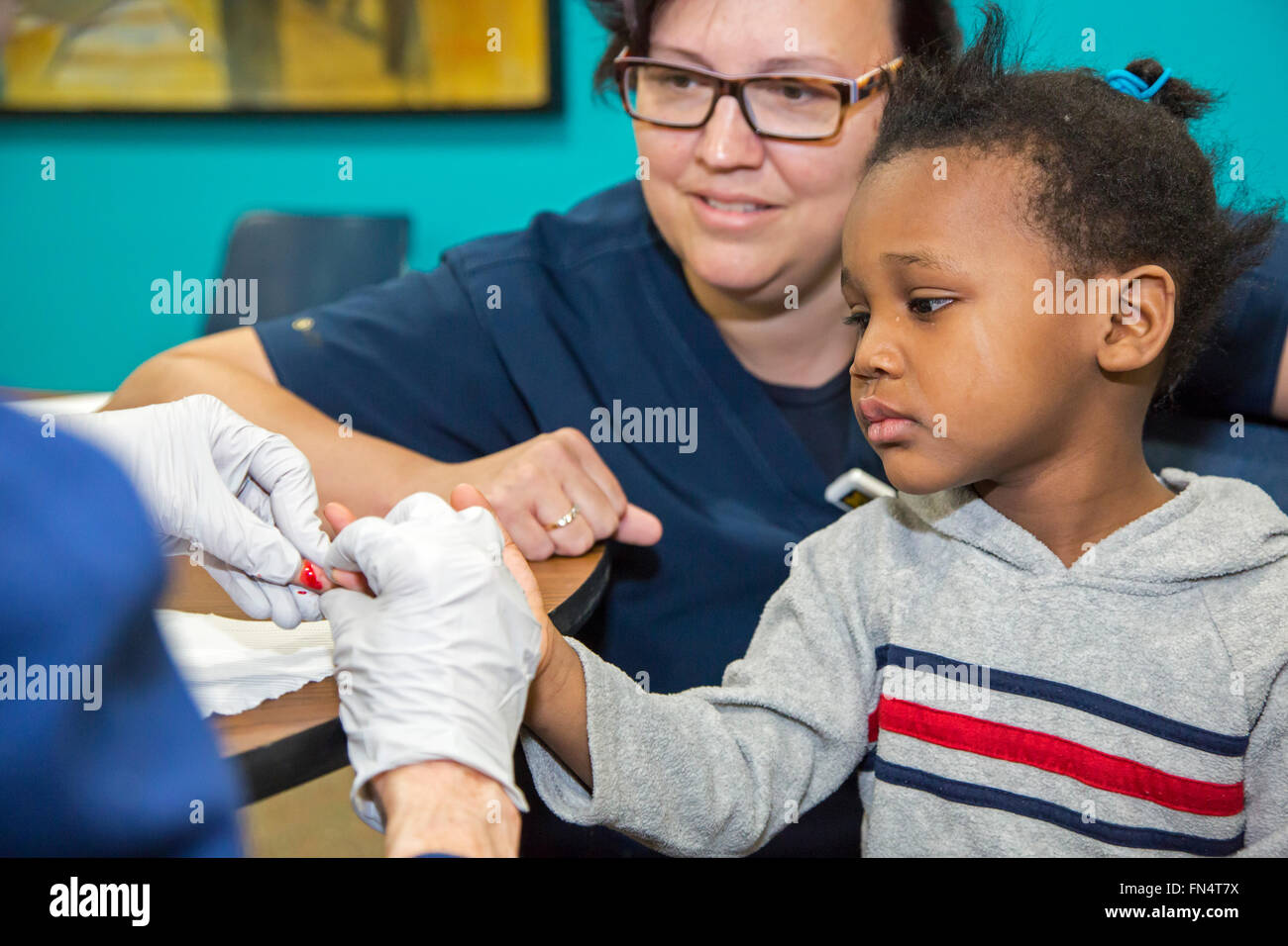 Flint, Michigan - une infirmière bénévole recueille un échantillon de sang d'Maylaysia Valsin-Cooley, 3, pour le contrôle d'exposition au plomb. Banque D'Images