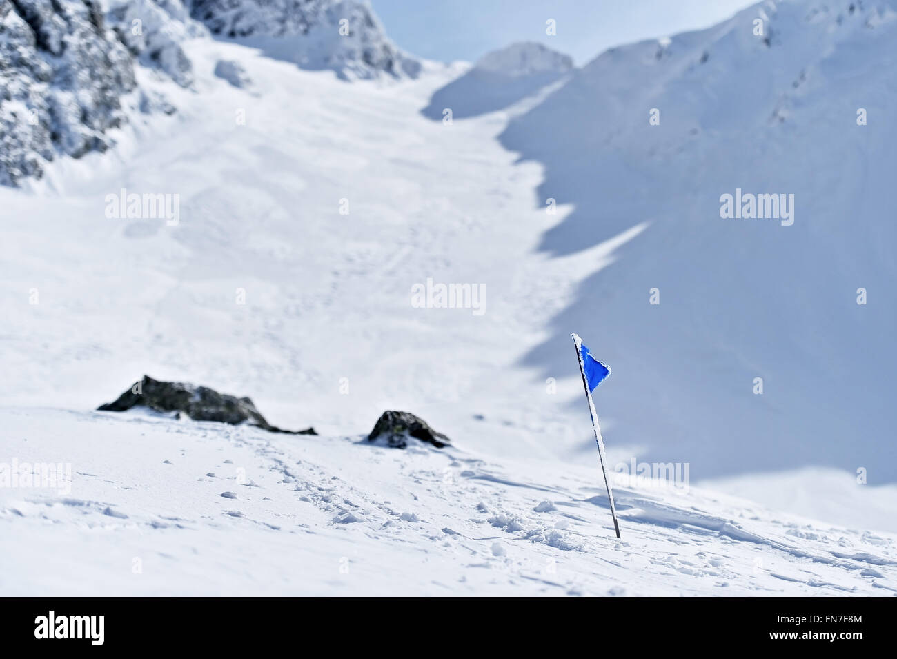 Drapeau bleu soufflé par le vent sur une montagne en hiver Banque D'Images