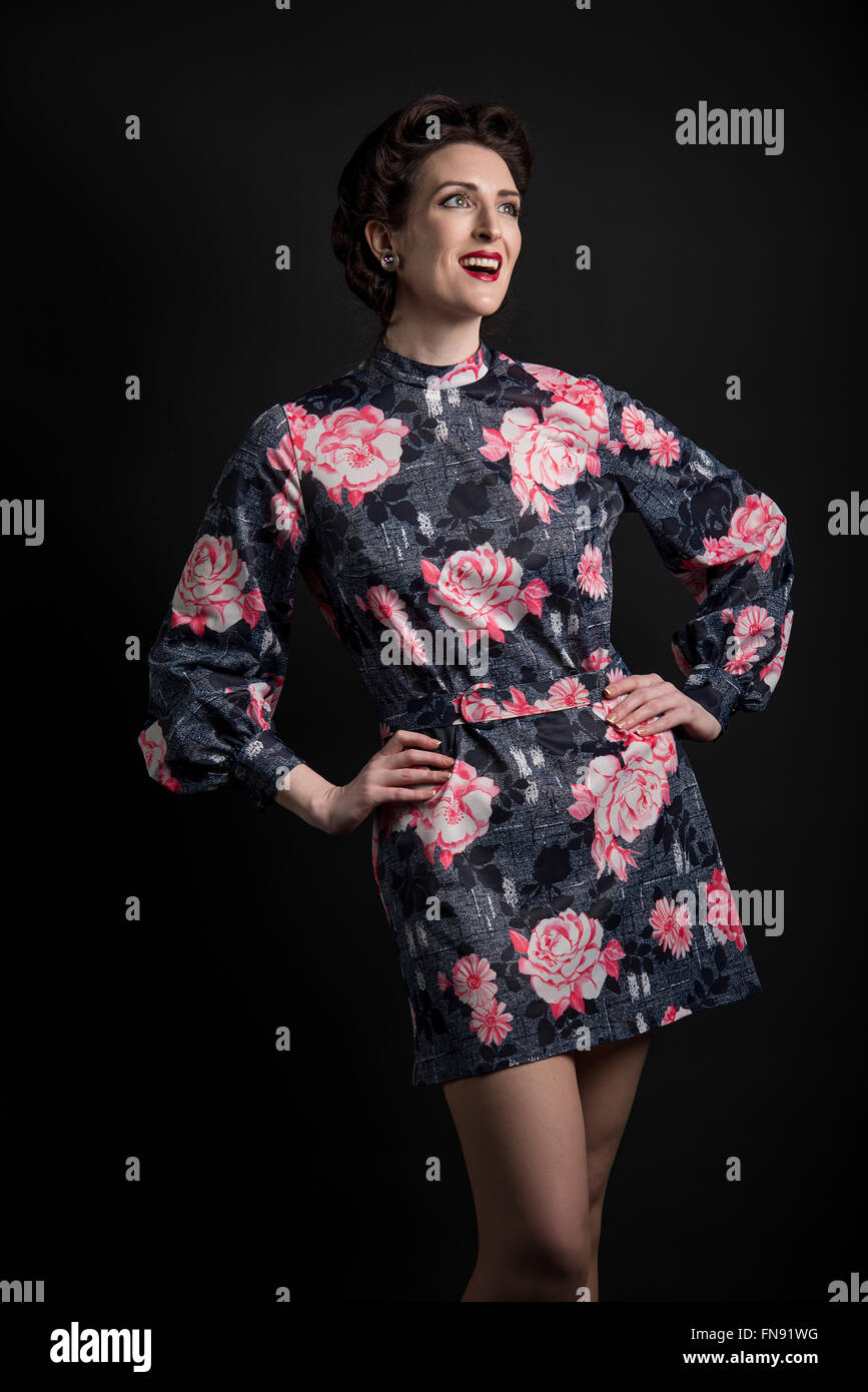 Smiling woman wearing a vintage robe noire avec motif rose Banque D'Images