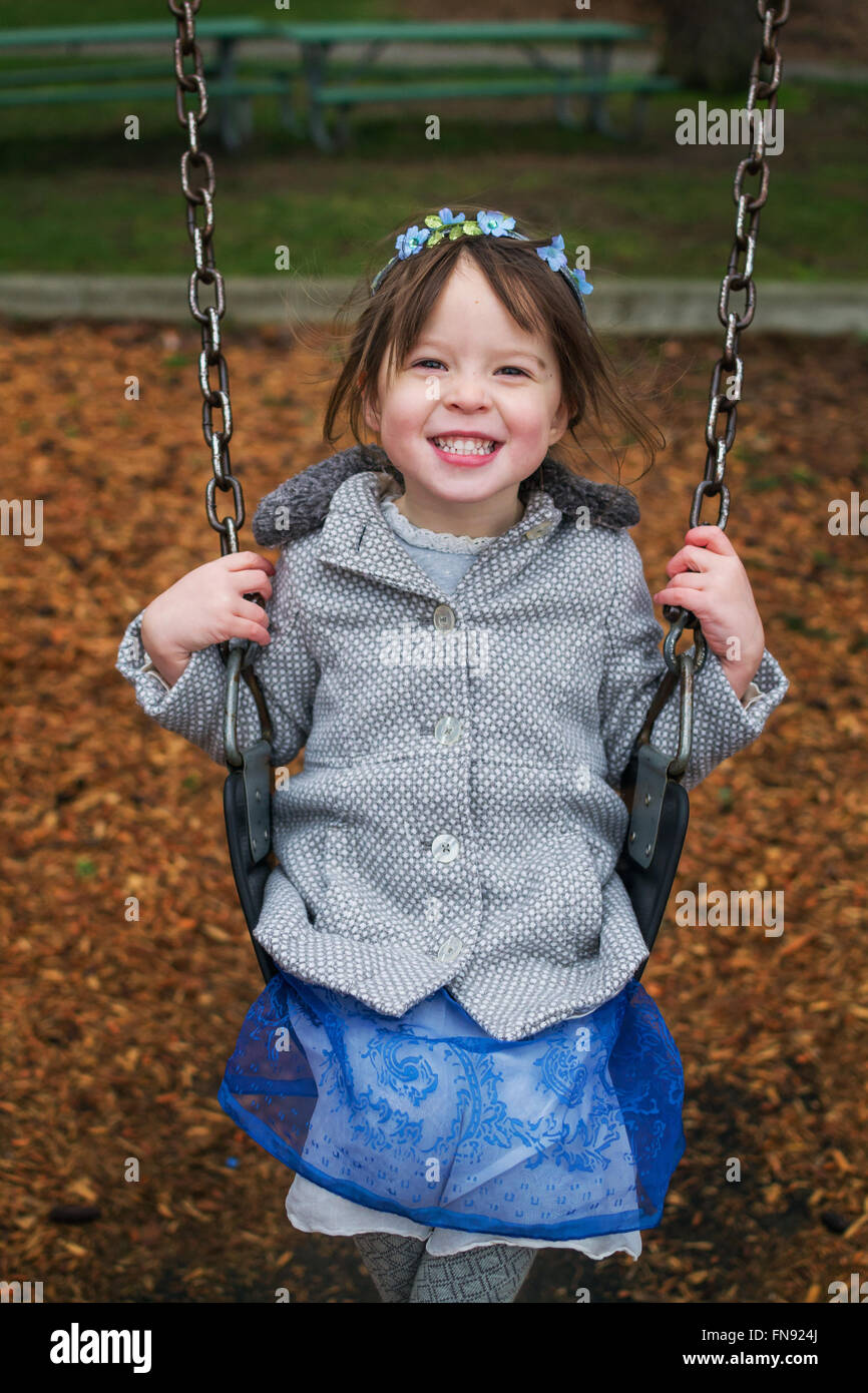 Smiling girl sitting on swing Banque D'Images