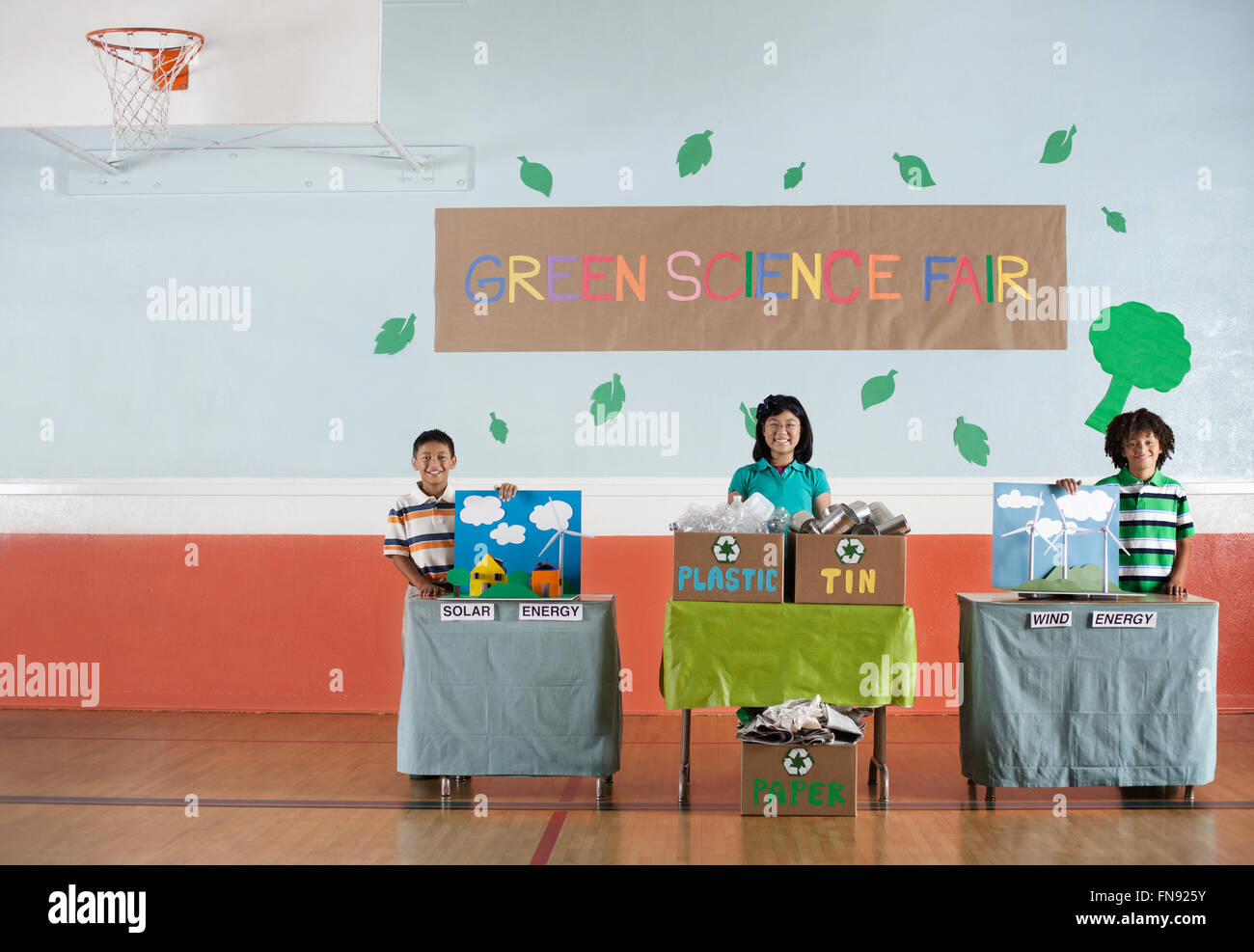 Trois étudiants debout par leur projet affiche lors d'une foire scientifique vert événement. Banque D'Images