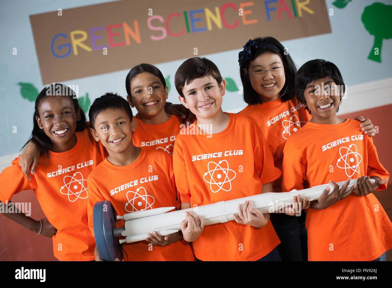 Les étudiants de la Science Club sous le signe permanent Green Science Fair, tenant une fusée longue. Banque D'Images