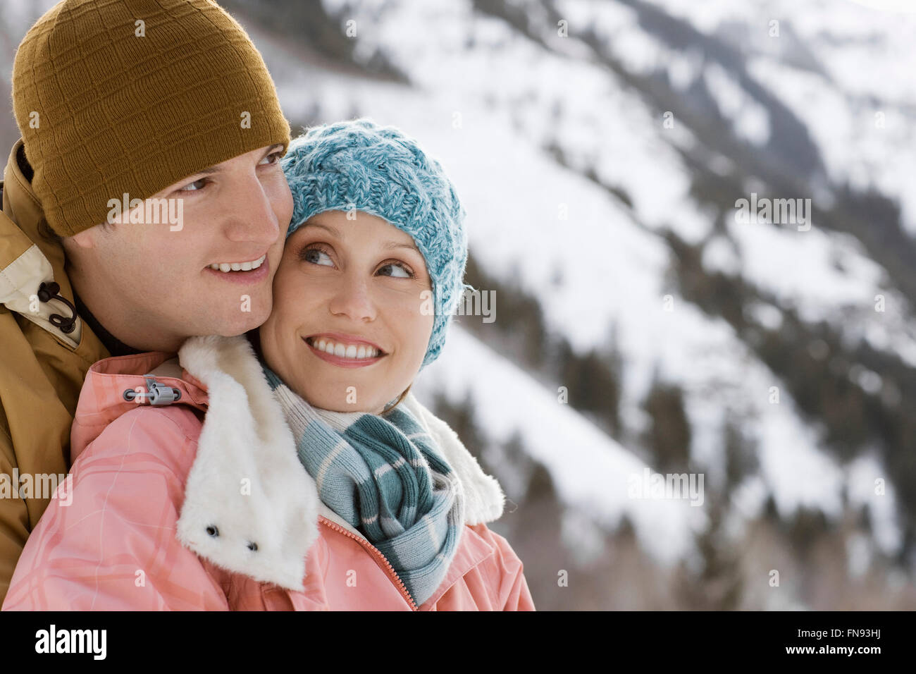 Un autre couple, homme et femme, dans les montagnes enneigées. Banque D'Images