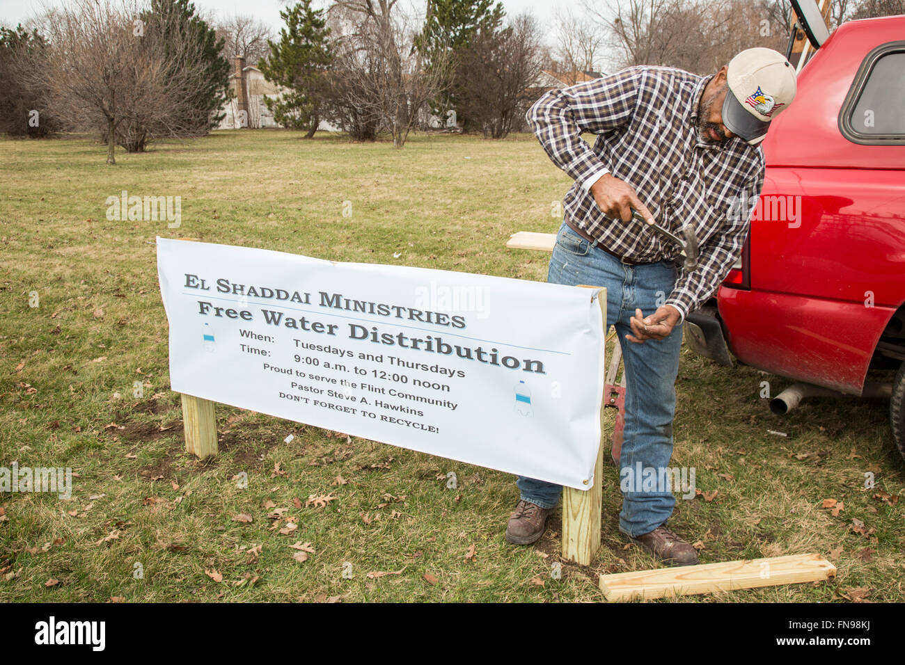 Flint, Michigan - un membre d'El Shaddai Église de Dieu en Christ posts signe qui annonce de la distribution de l'eau pour les résidents. Banque D'Images