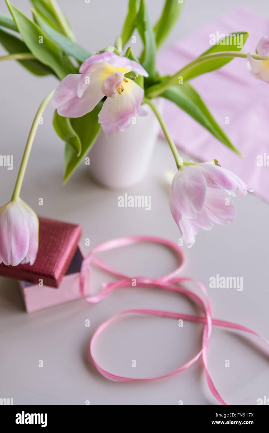 Tulipes roses dans un vase avec ruban et papier Banque D'Images