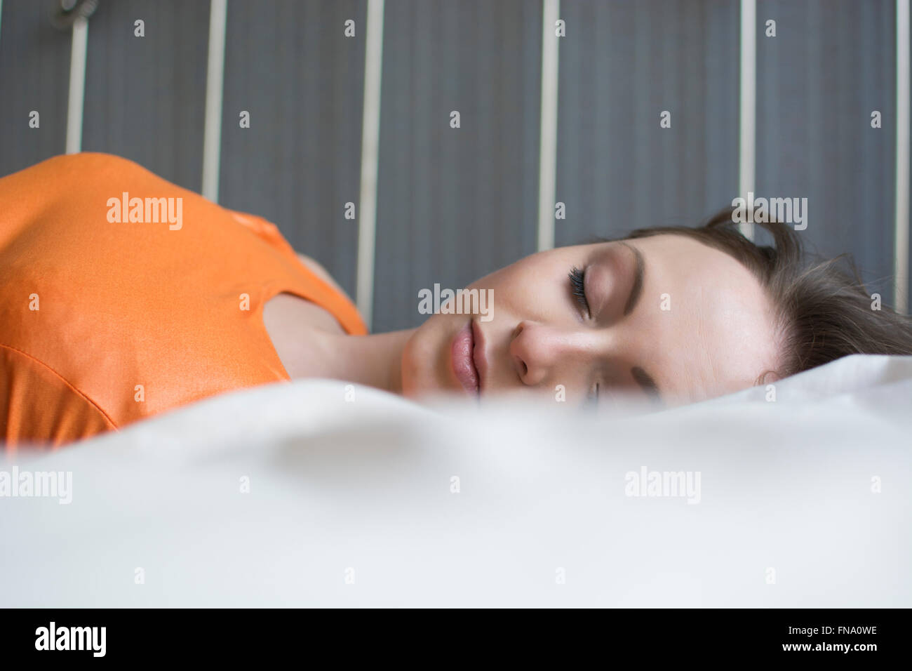 Jeune femme au lit seul Banque D'Images