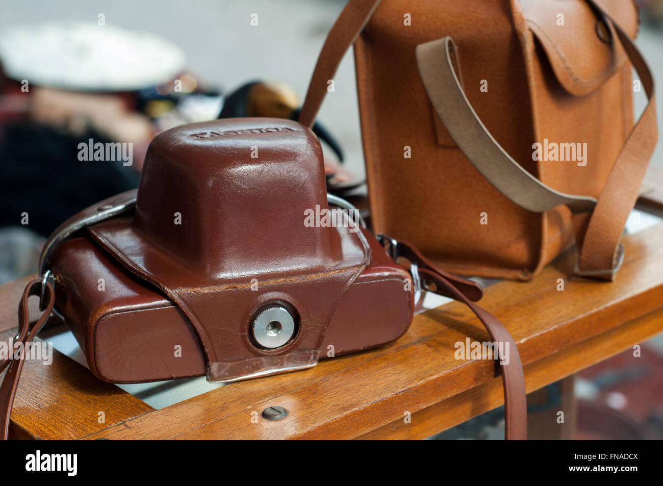 Old vintage 35mm appareil photo reflex en cas de cuir Poche sur du marché de la photographie arrête sur carboot sale in Bath, Royaume-Uni. Banque D'Images