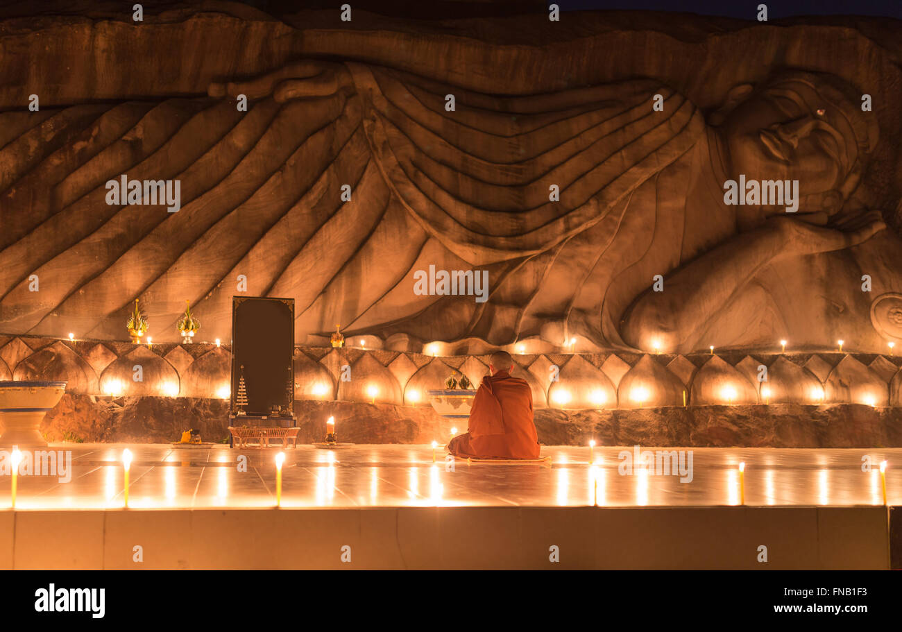 Vue arrière d'un moine asiatique méditant dans un temple bouddhiste Banque D'Images