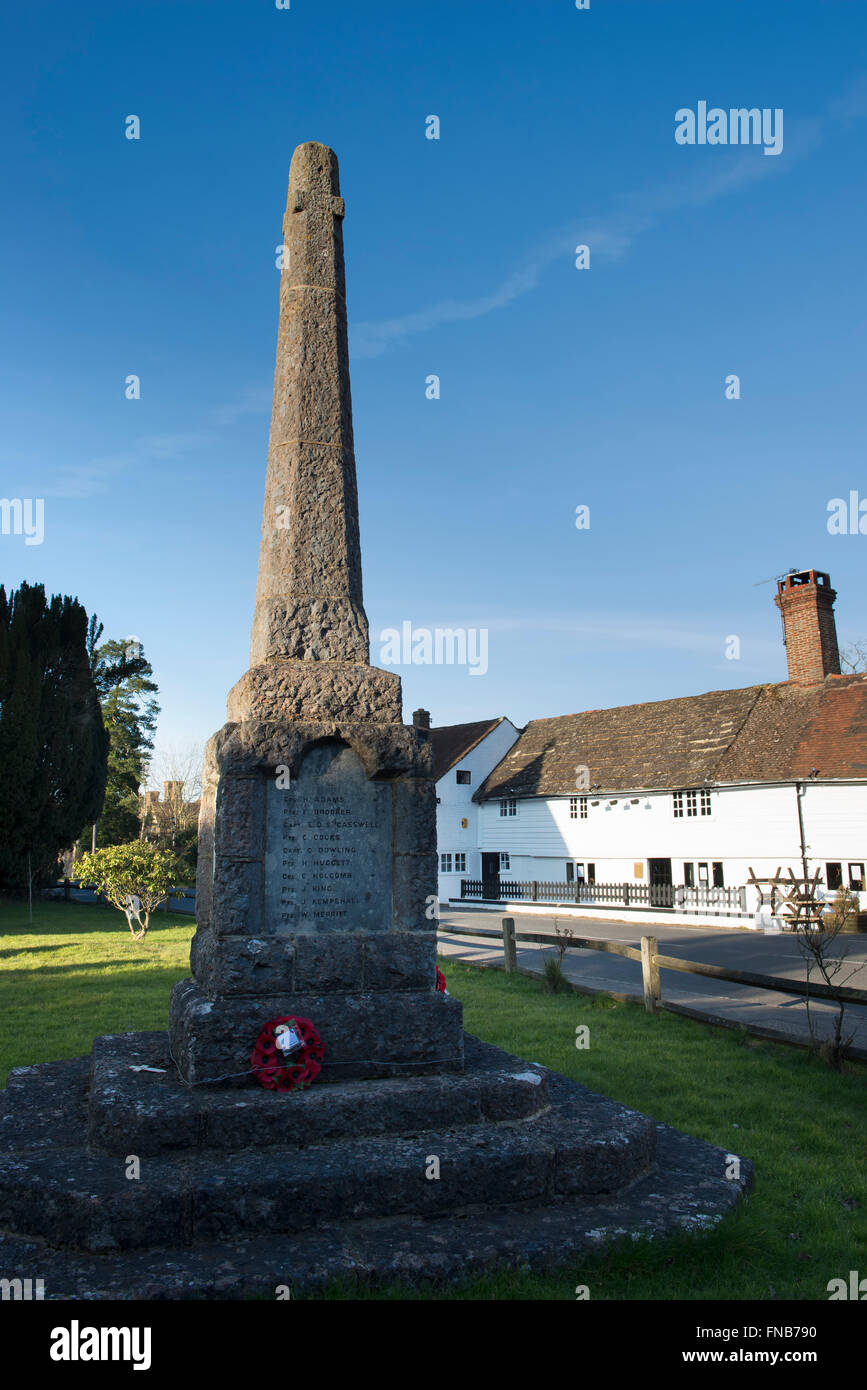 Le mémorial de guerre avec The Plough Inn dans l'arrière-plan dans le village de Rusper, West Sussex, UK Banque D'Images