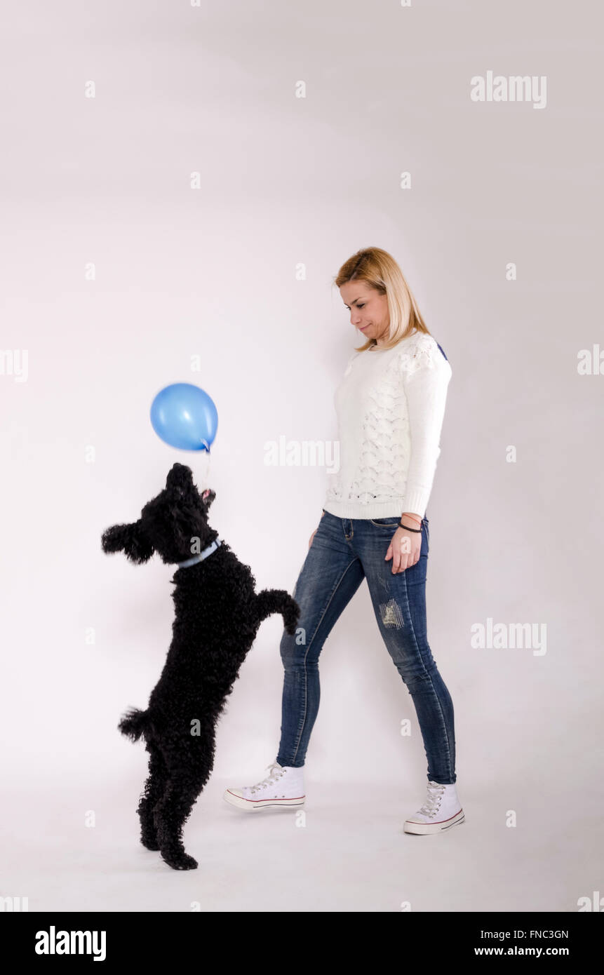 Jeune femme jouant avec un caniche noir. Banque D'Images