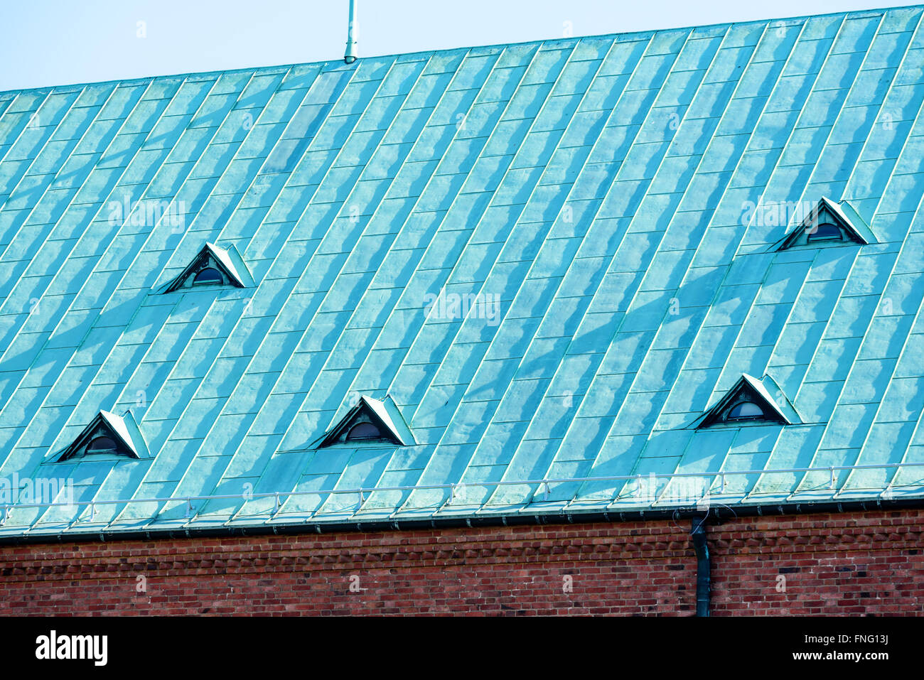 Un toit en cuivre avec des petites fenêtres. Le cuivre est vieux et a oxydé en une couleur verdâtre, donnant le toit une belle patine. Banque D'Images