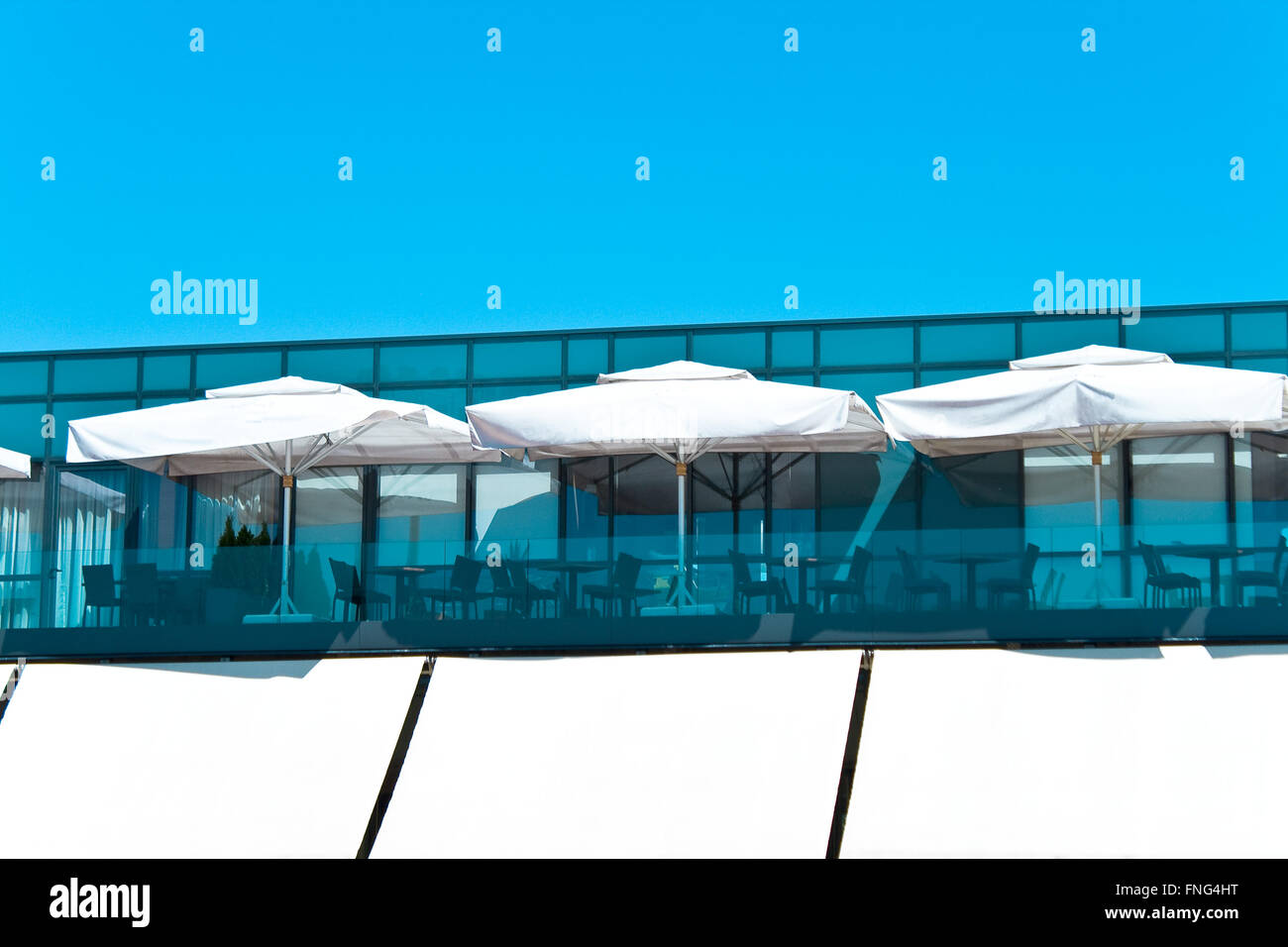 Terrasse d'un restaurant avec des pare-soleil blanc Banque D'Images