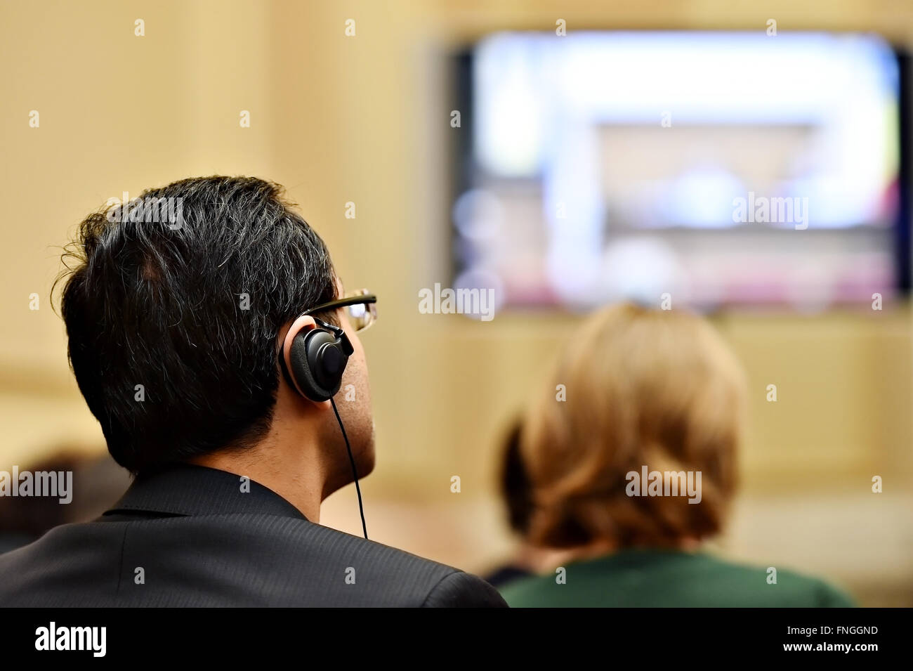 À l'aide de personnes méconnaissables dans l'oreille d'écouteurs pour la traduction pendant l'événement Banque D'Images