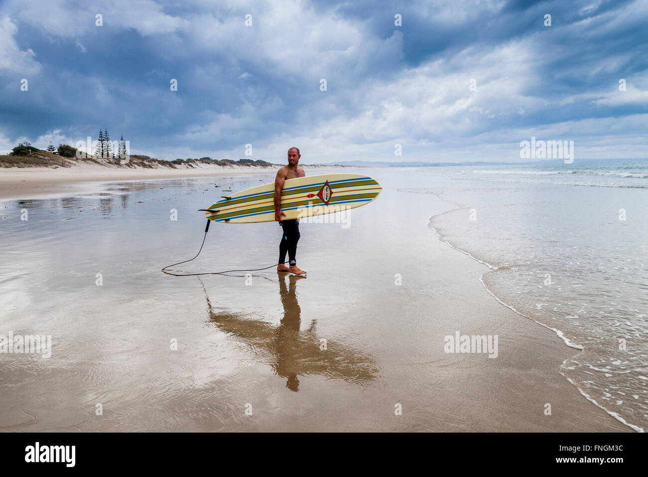 Un jeune homme va surf, waipu cove, waipu, Northland, Nouvelle-Zélande Banque D'Images