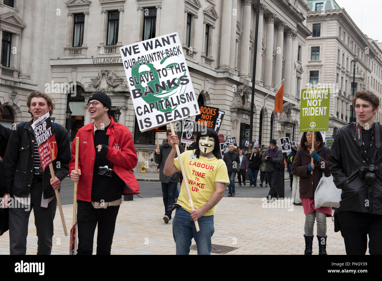 Manifestant portant masque anonyme est holding a placard 'Le capitalisme est mort' au cours de la manifestation anti-nucléaire à Londres. Banque D'Images