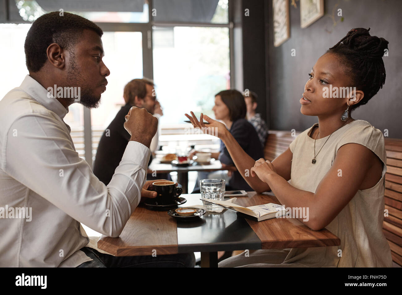 Femme africaine et l'homme de discuter affaires Idées à occupé cafe Banque D'Images