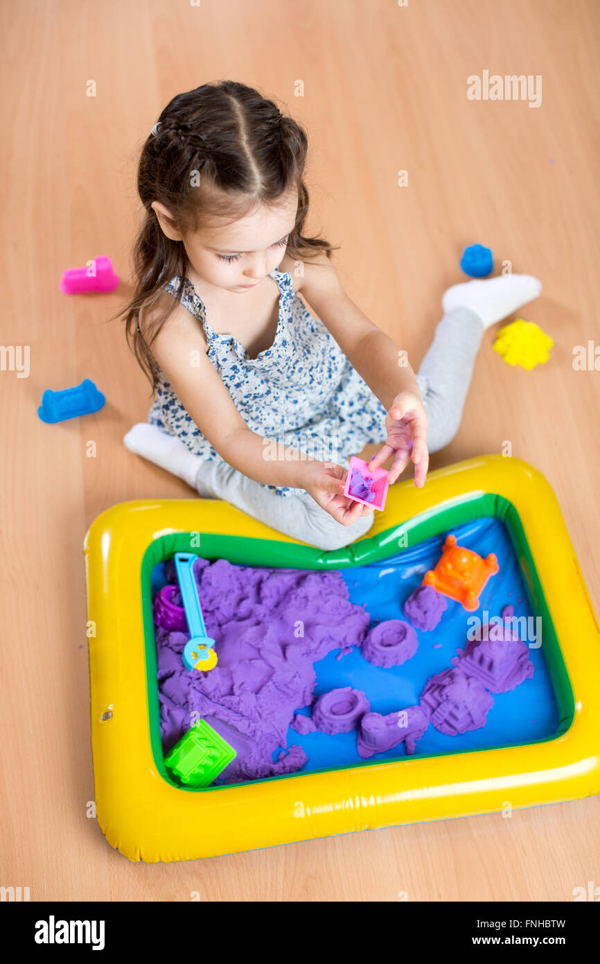 Fille enfant sculpte kinetic sable en salle de jeu. Centre préscolaire. Banque D'Images