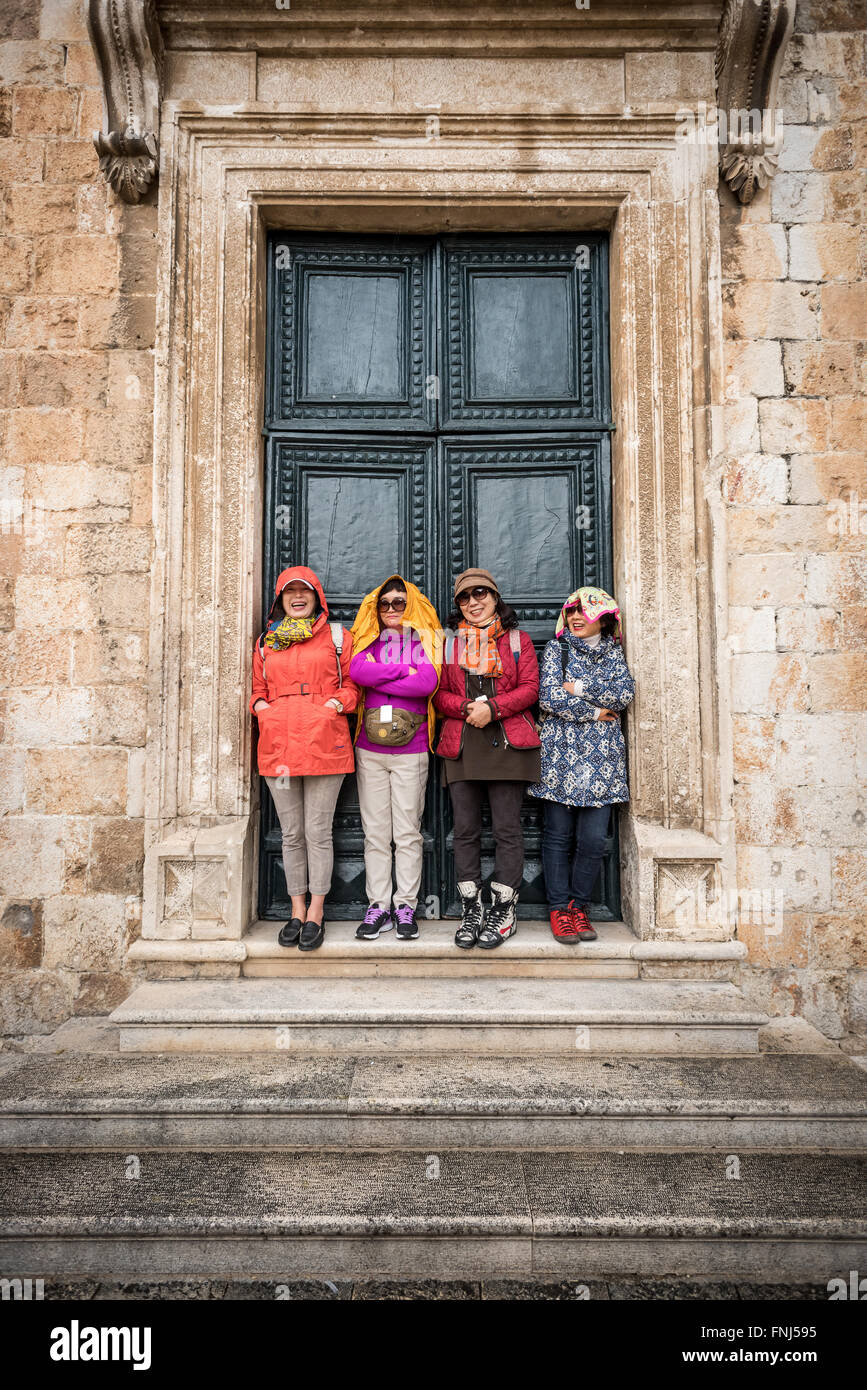 Les touristes japonais un abri contre une pluie diluvienne lors d'une visite à Dubrovnik. Banque D'Images
