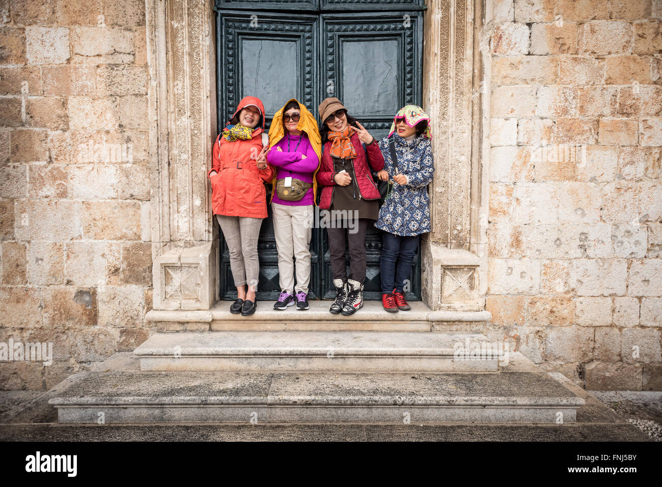 Les touristes japonais un abri contre une pluie diluvienne lors d'une visite à Dubrovnik. Banque D'Images