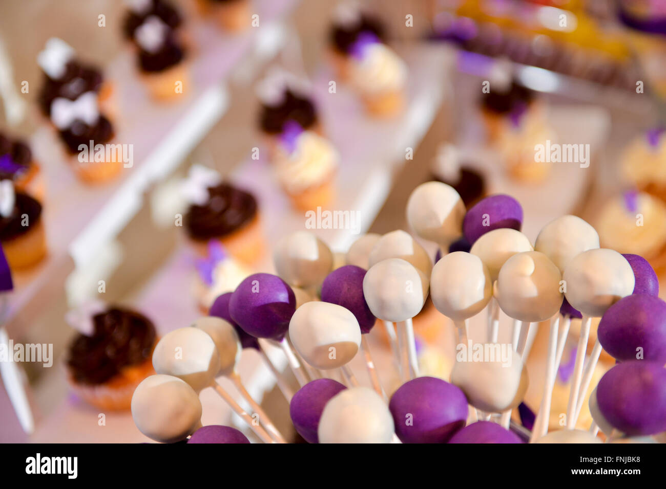 Mauve et blanc lollipops avec beaucoup de cake en arrière-plan Banque D'Images