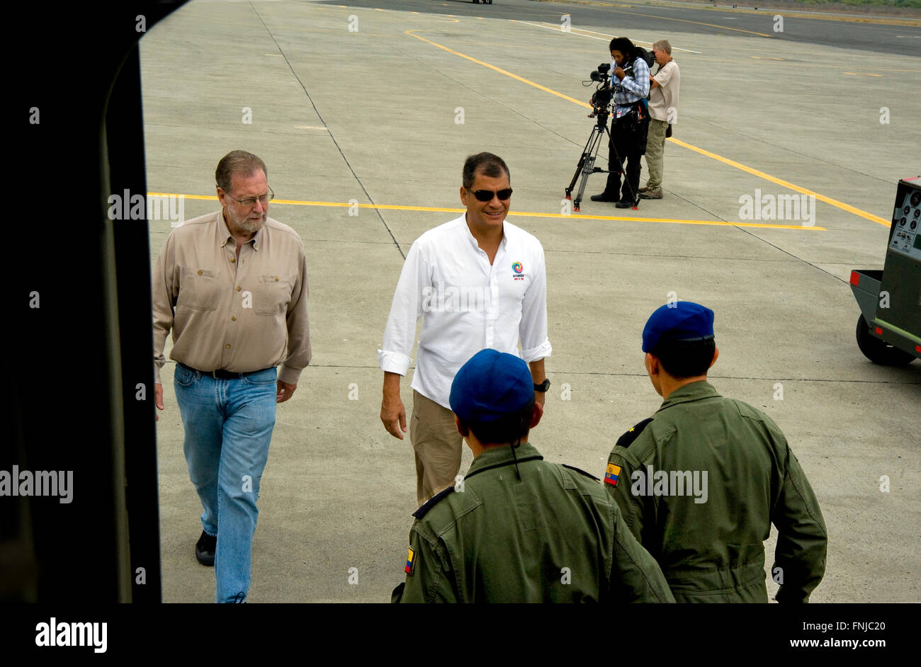 Le président Rafael Correa de l'Équateur et show d'accueil Peter Greenberg sont remplies par le personnel militaire comme ils sont sur le point de monter à bord d'un avion à un aéroport militaire à Quito lors du tournage d'Équateur : La Tournée royale. Banque D'Images