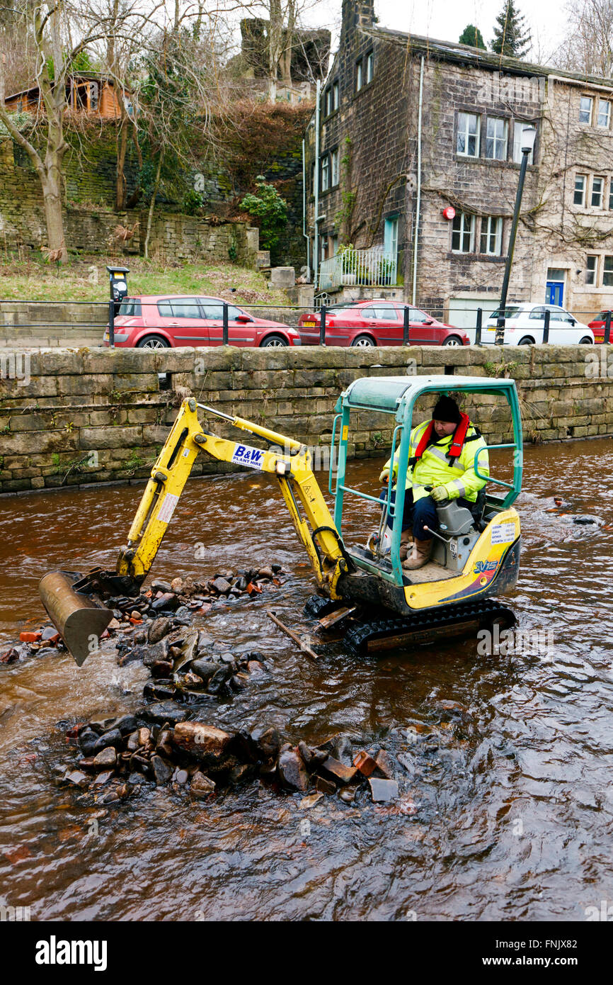 Hebden Bridge, Yorkshire, UK. Mar 15, 2016. Un creuseur rassemble des remblais déposés à Hebden Beck. La rivière est en cours d'desilted et effacée après le boxing day les inondations de décembre 2015 © Graham Hardy/Alamy Live News Banque D'Images