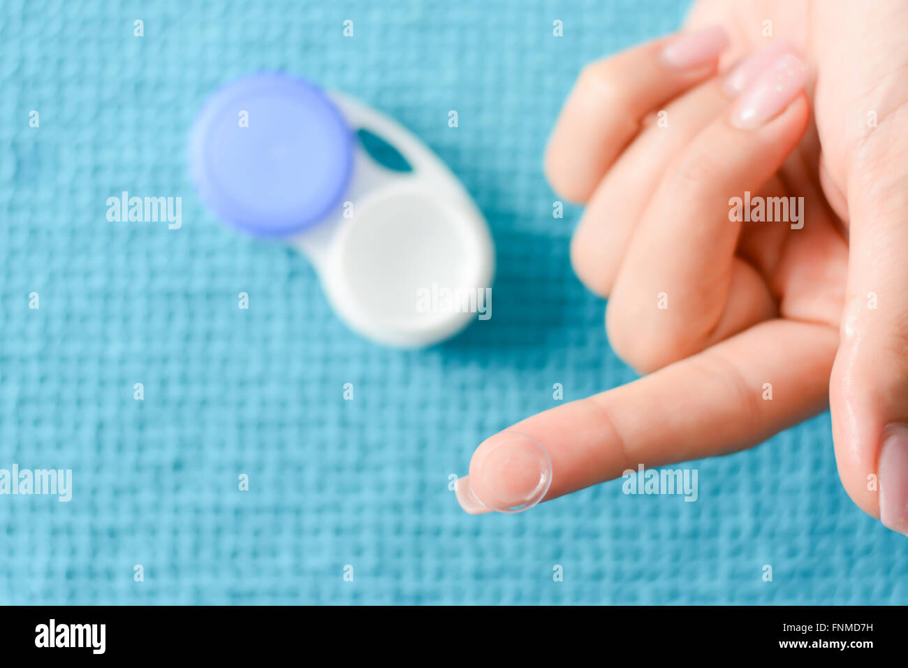 Lentille souple sur un doigt de la femme, avec cas ouvert en arrière-plan Banque D'Images