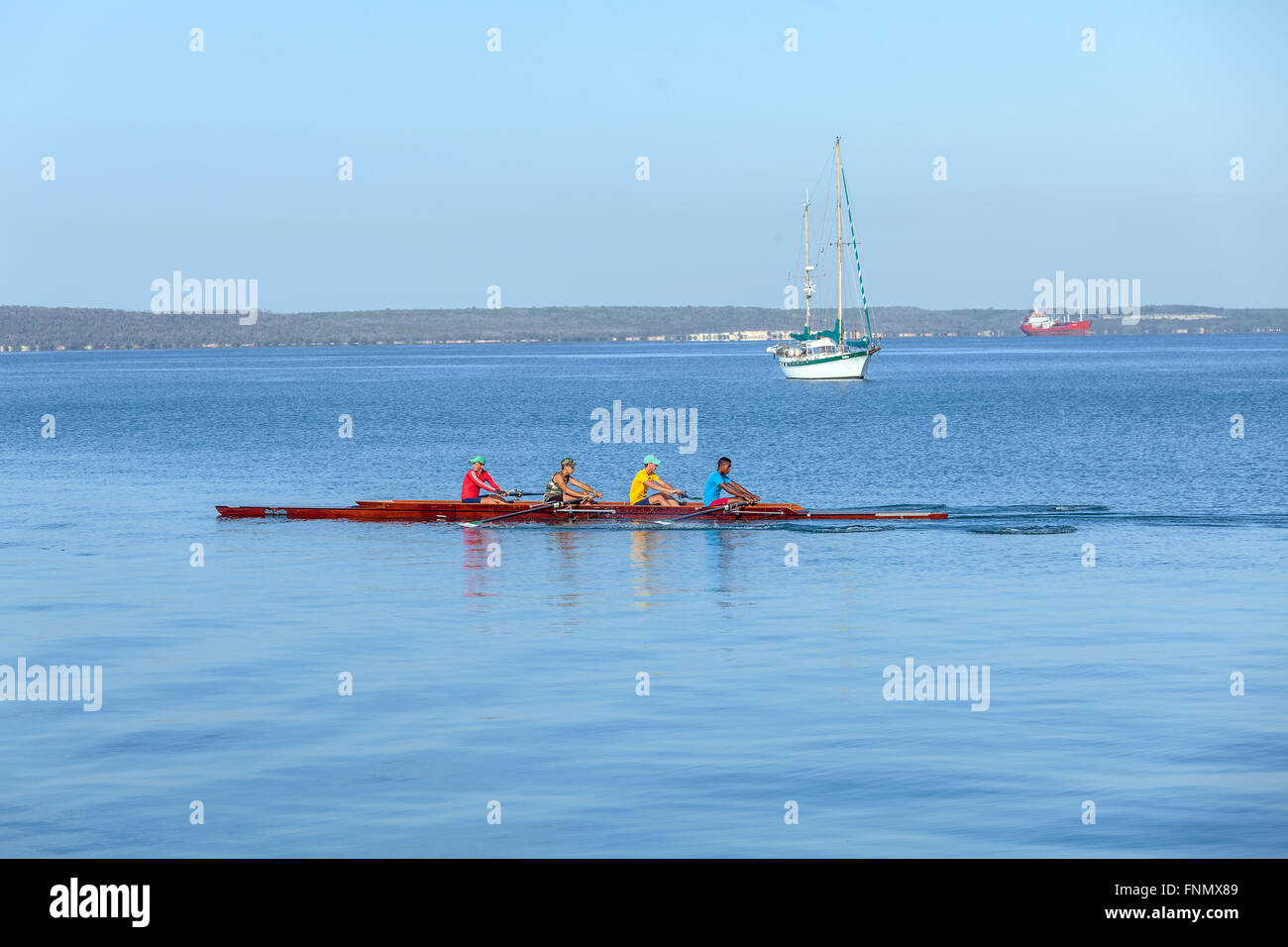 CIENFUEGOS, CUBA - 30 mars 2012 : l'équipe d'aviron de quatre hommes et yacht usage éditorial uniquement. Banque D'Images