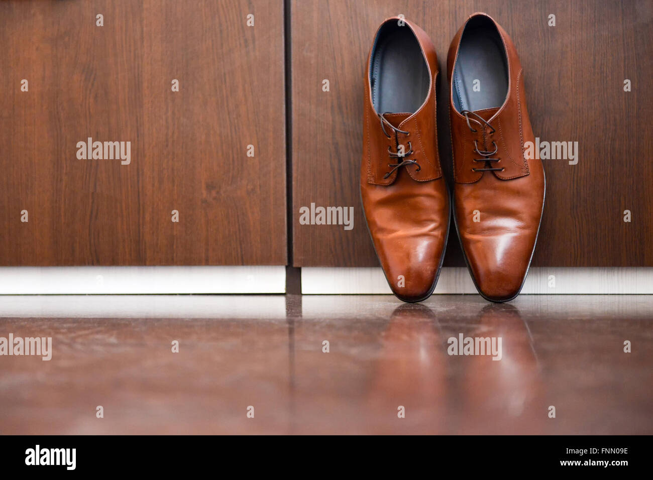 Chaussures en cuir brun assis sur un plancher de bois Banque D'Images
