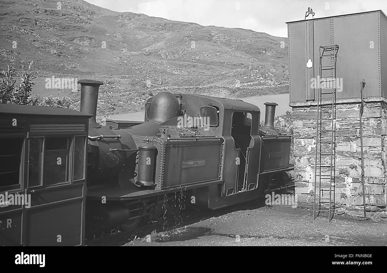 Voie étroite de chemin de fer gallois Festiniog double Fairlie locomotive à vapeur prenant l'eau dans les années 1930 Banque D'Images