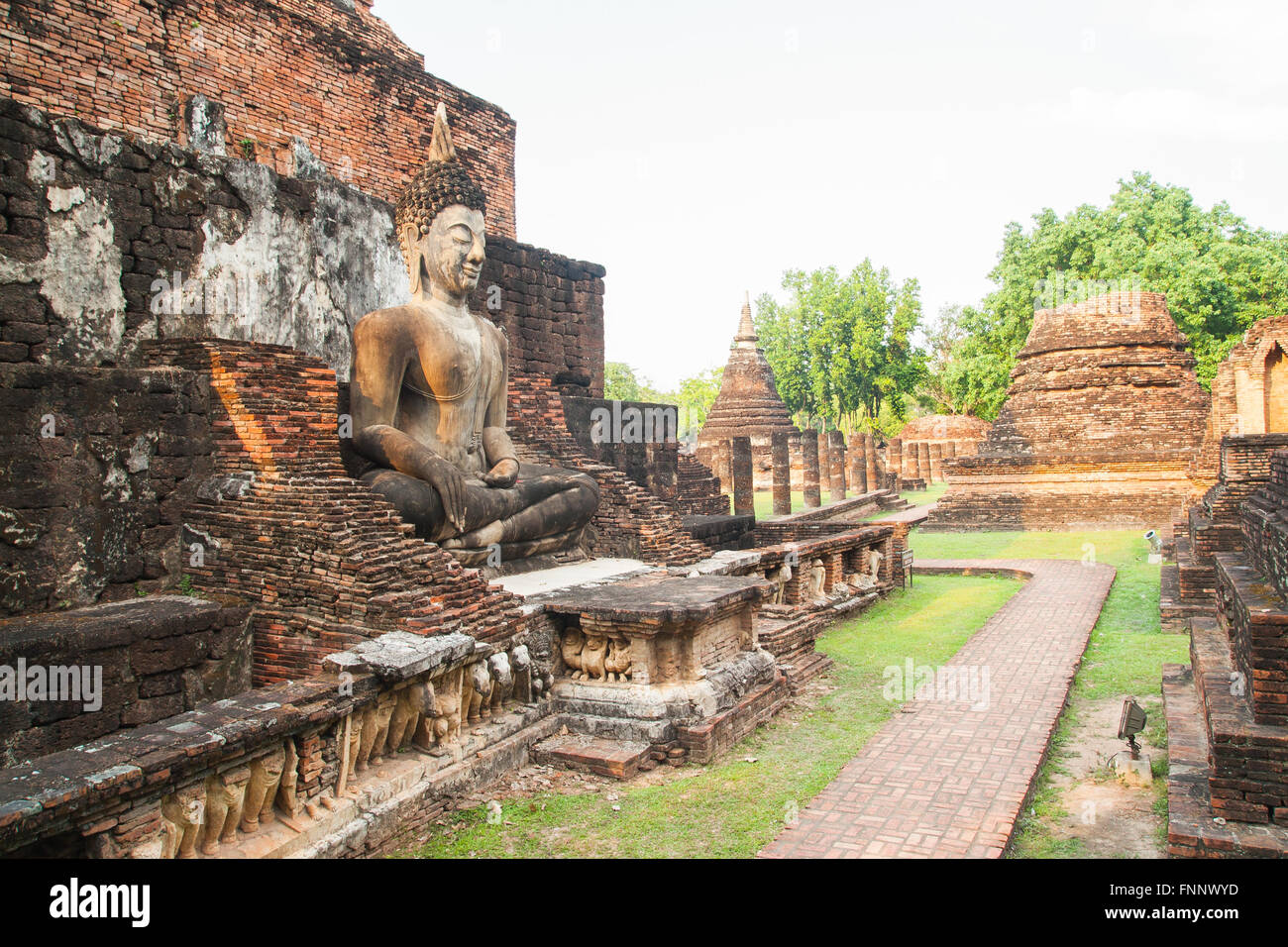 Sculpture Bouddha assis parmi les ruines en parc historique de Sukhothai, Thaïlande Banque D'Images