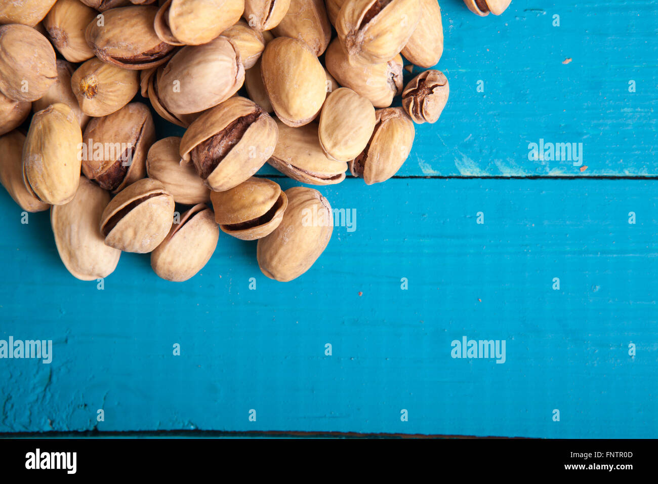 Les pistaches salées sur une table en bois bleu Banque D'Images