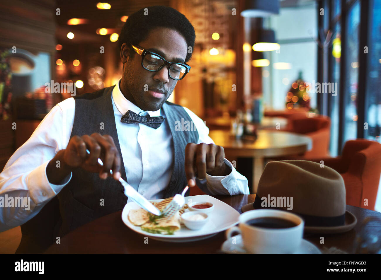 Jeune homme élégant déjeunant à cafe Banque D'Images