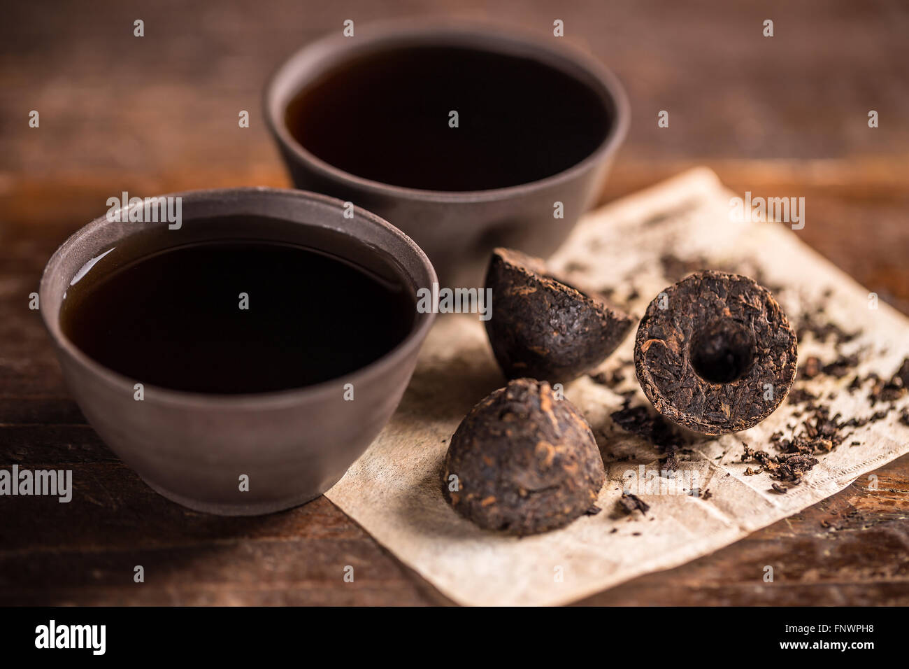 Tasse de thé noir avec des feuilles de thé pressé Banque D'Images