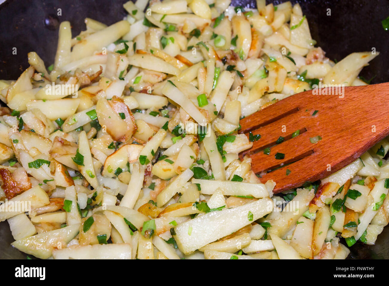 Pommes de terre sautées avec des oignons verts est cuite dans une casserole Banque D'Images