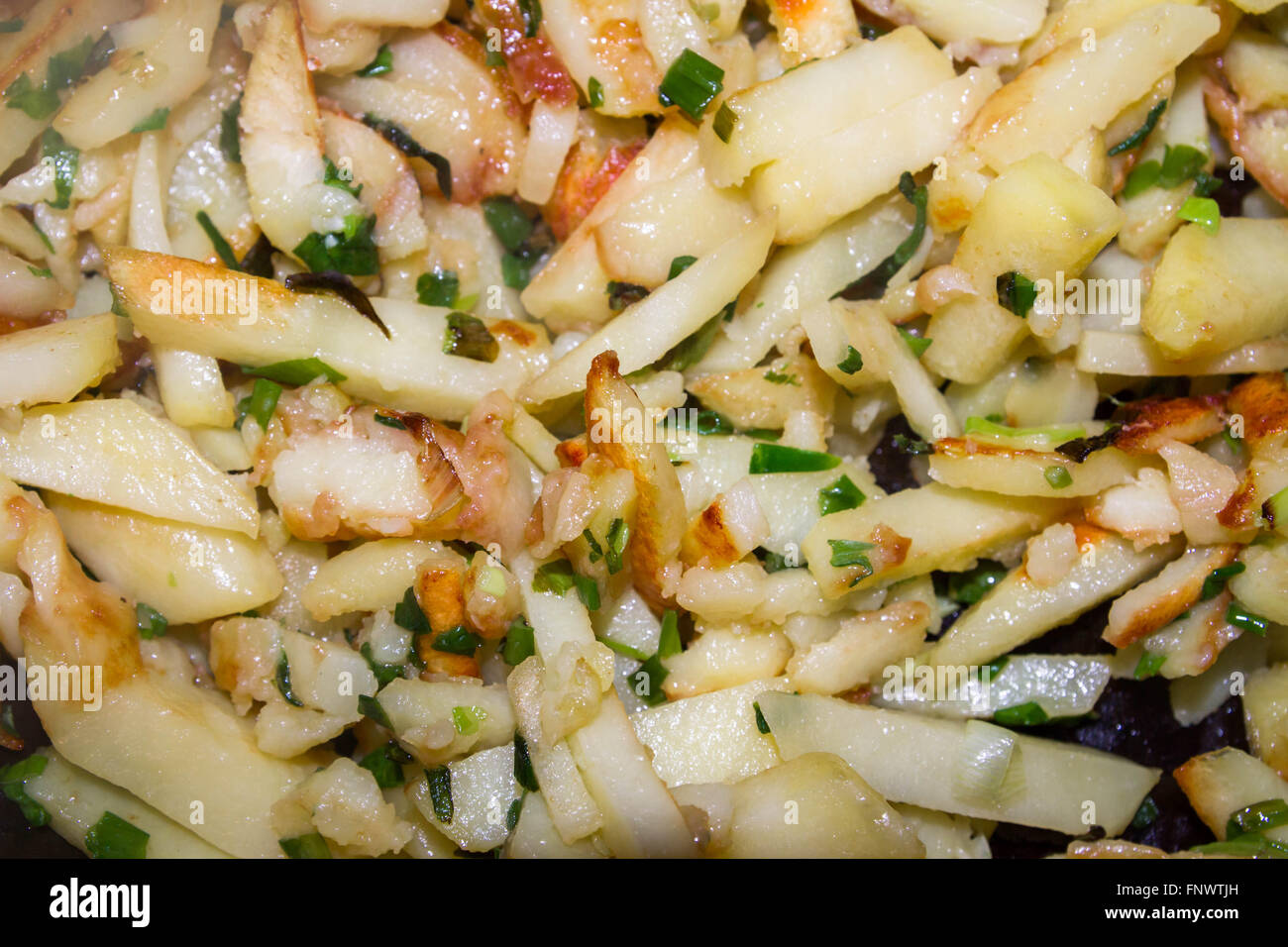 Pommes de terre sautées avec des oignons verts est cuite dans une casserole Banque D'Images