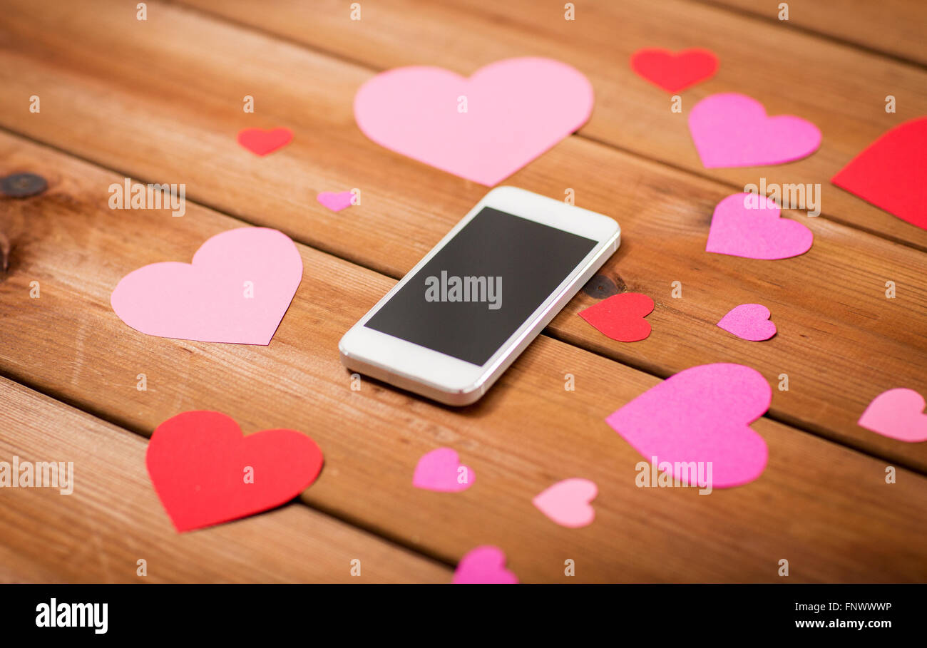 Close up of smartphone et coeurs en bois Banque D'Images