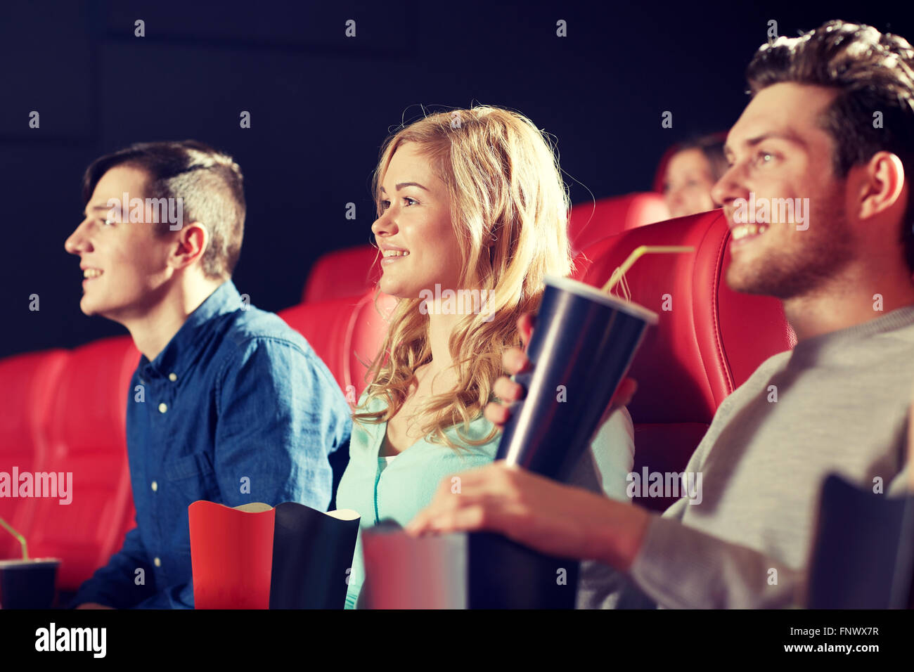 Happy friends watching movie in theatre Banque D'Images