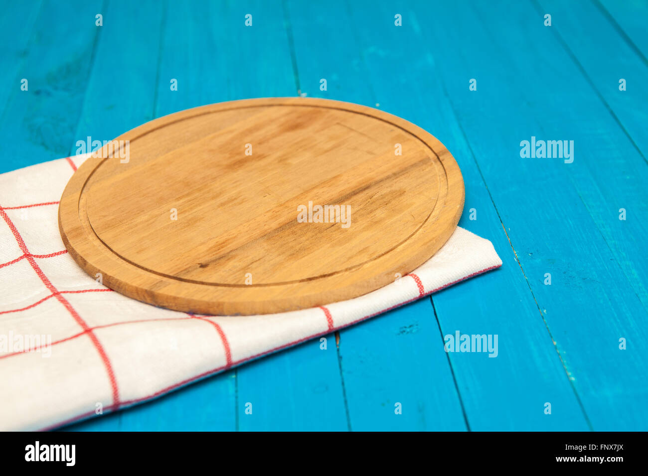 Planche à découper ronde sur une serviette sur un fond de bois Banque D'Images