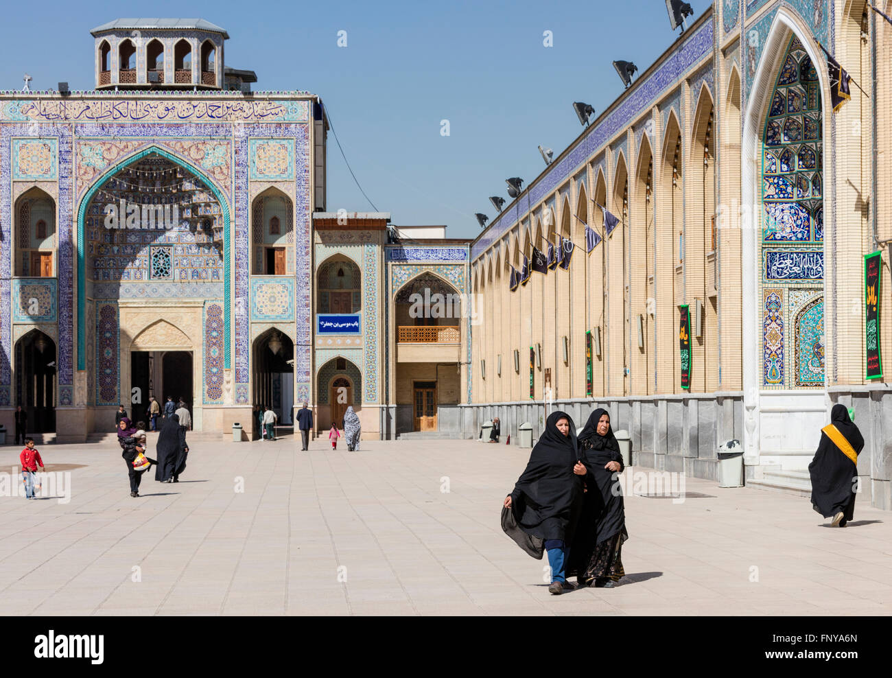 Les visiteurs, y compris les familles et tchador femmes, sur le parvis de la mausolée Shah Cheragh, Shiraz, Iran Banque D'Images