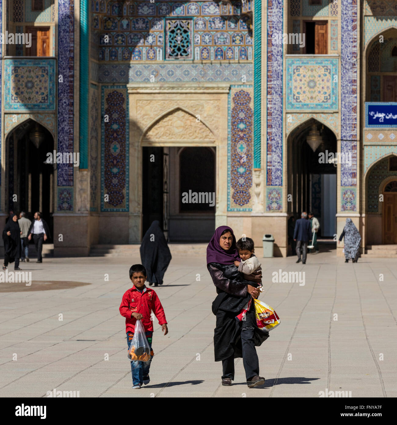 Les visiteurs, y compris les familles et tchador femmes, sur le parvis de la mausolée Shah Cheragh, Shiraz, Iran Banque D'Images