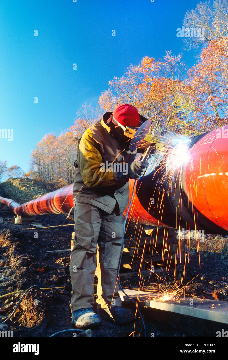 Man welding d'un pipeline dans la couture de la Virginie de l'Ouest rural ; USA Banque D'Images