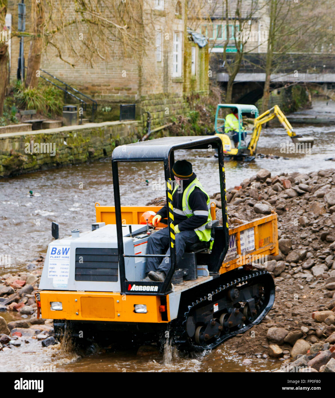 Hebden Bridge, Yorkshire, UK. Mar 15, 2016. Un petit porteur de chenilles en caoutchouc transporte loin décombres dragués de hebden Beck après les inondations à Hebden Bridge. © Graham Hardy/Alamy Live News Banque D'Images